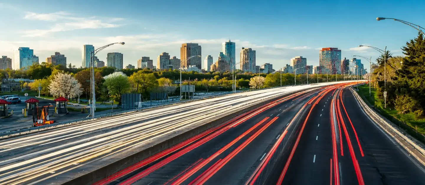 Autopista con luces de tránsito y ciudad de fondo